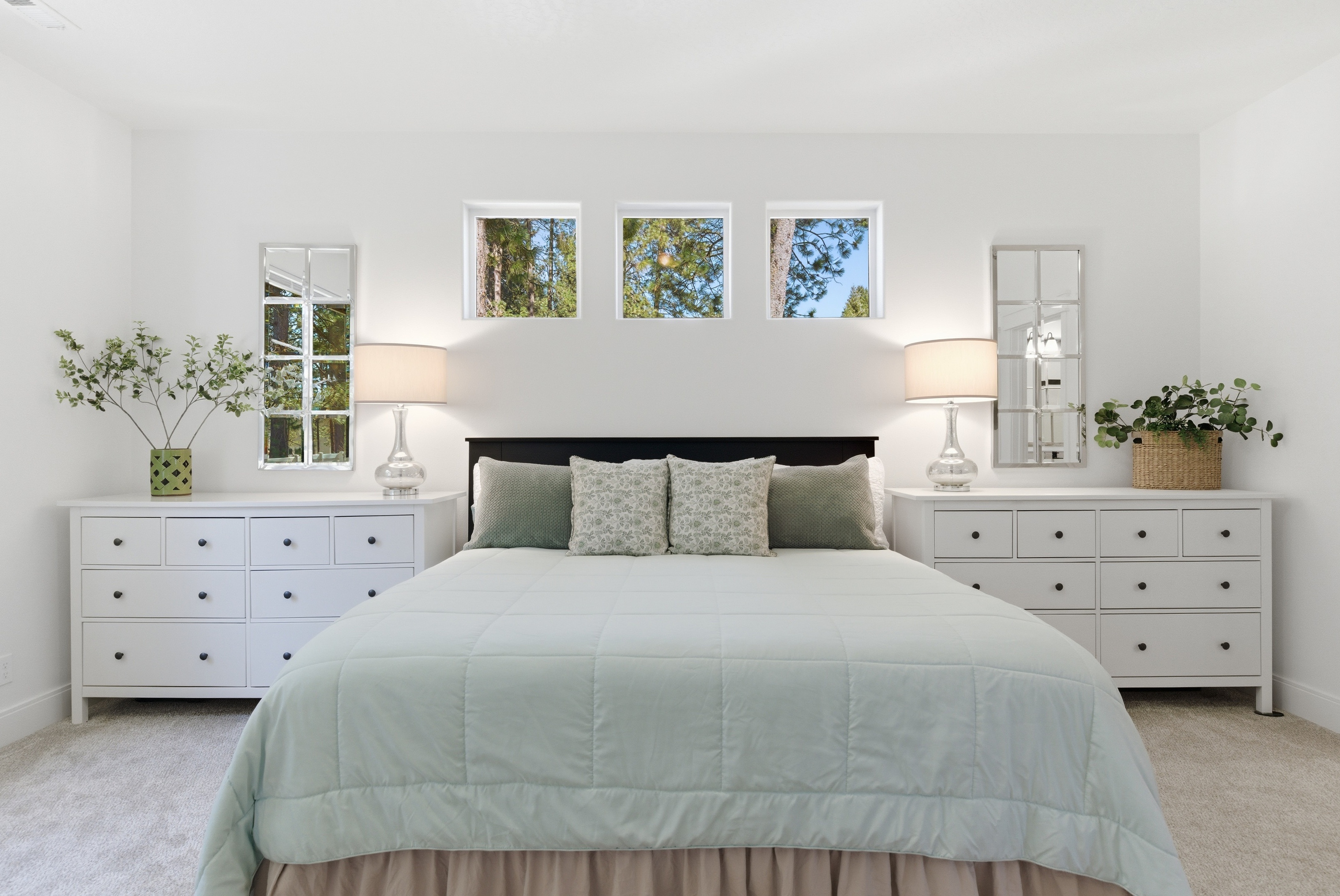 Bright master bedroom with triple windows and pine view