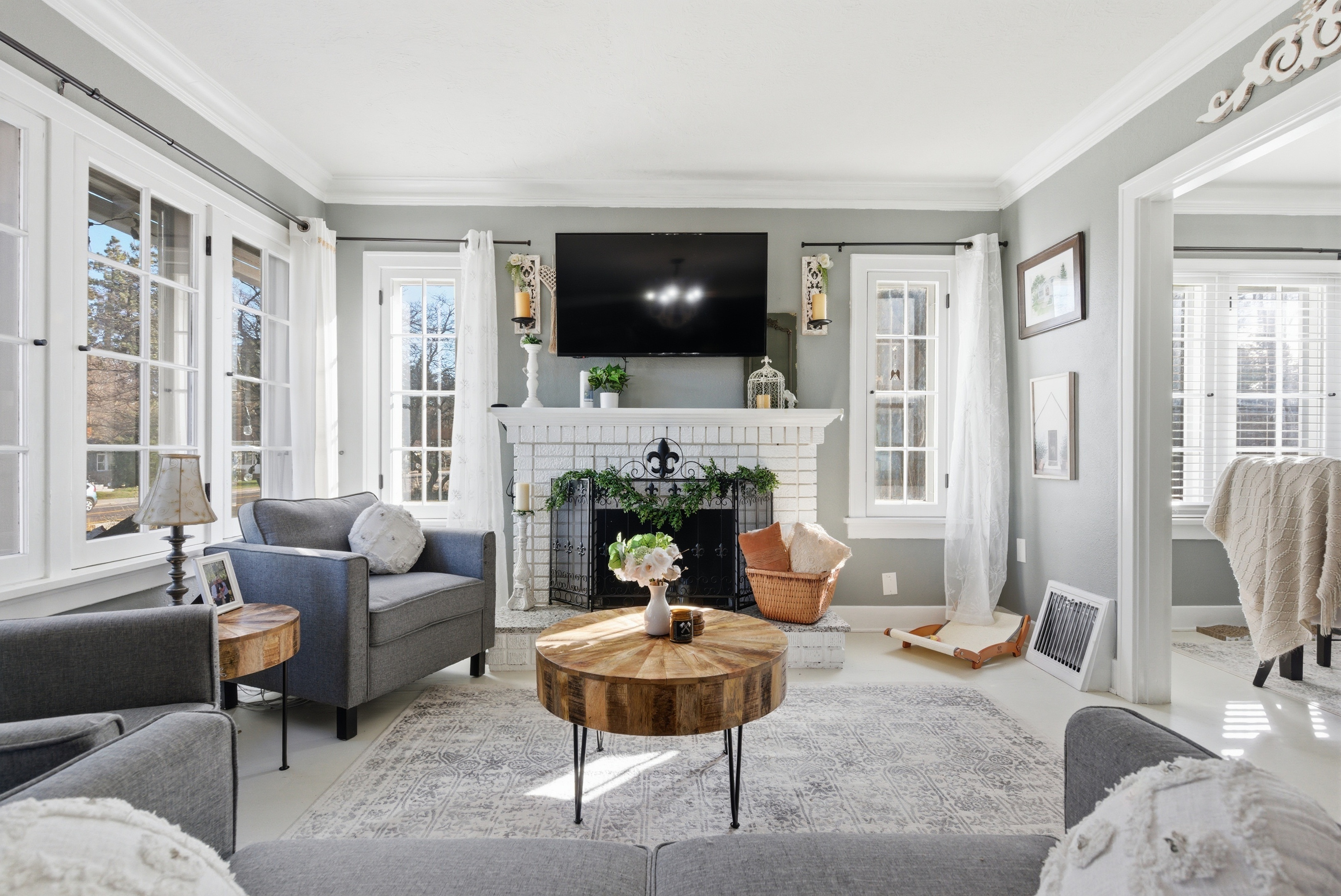 Sunlit living room with brick fireplace and French doors