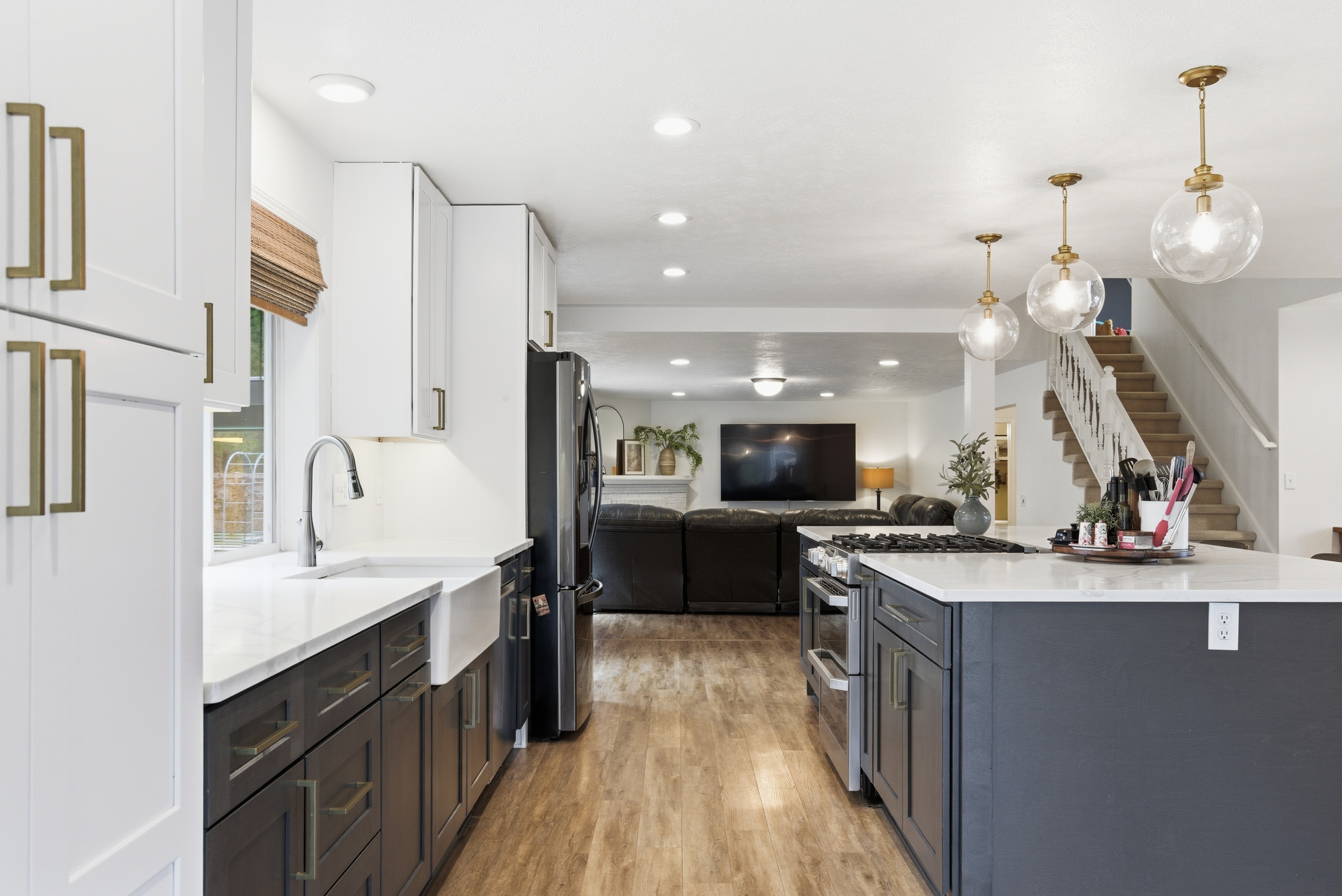 Open concept kitchen with farmhouse sink flowing into living area